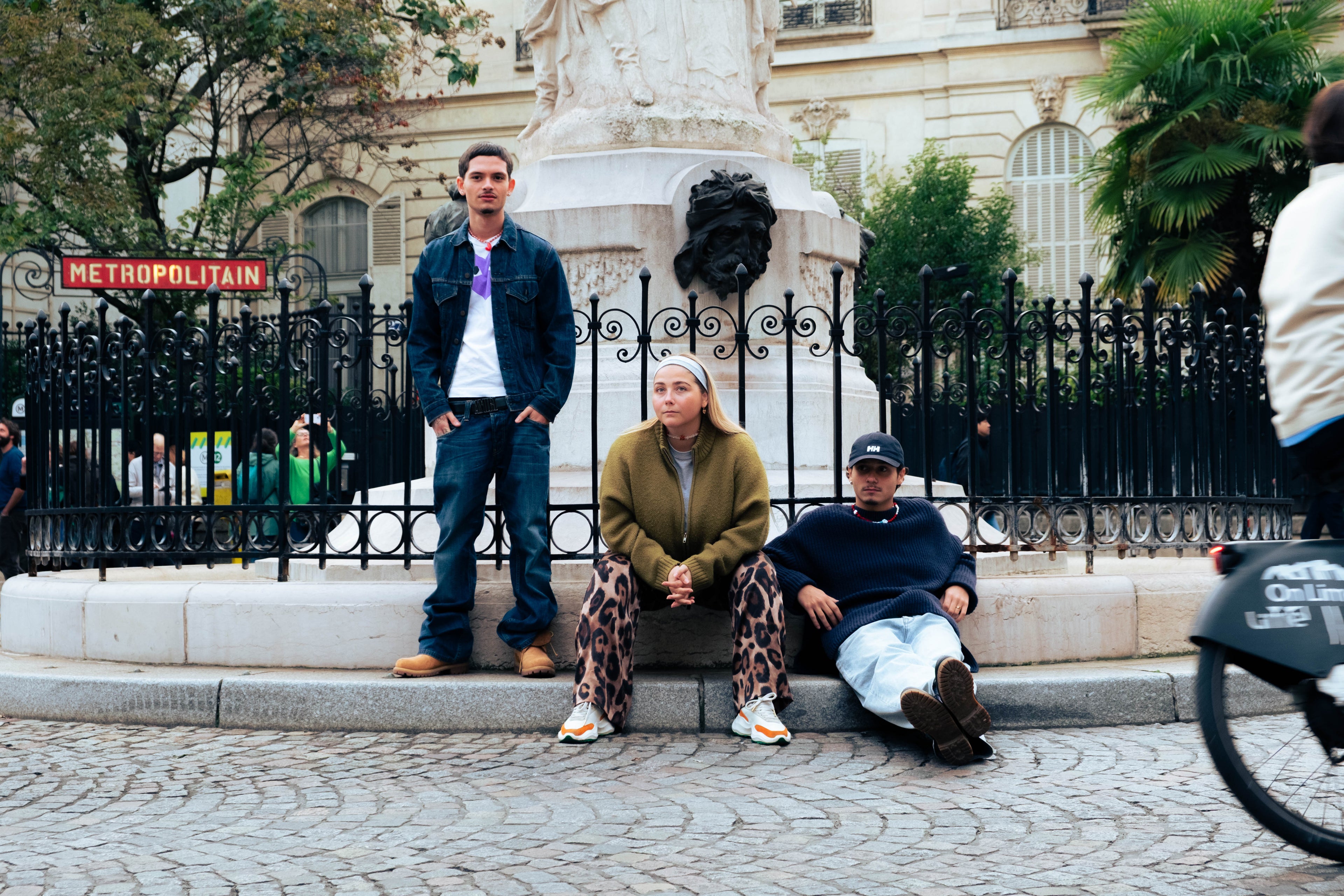Trois jeunes posent devant une station de métro parisienne, portant les bijoux colorés Bourjeone.