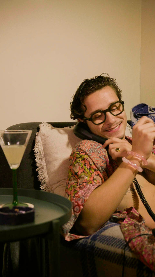 Homme portant le bracelet Sucre Bourjeone en verre rose irisé, bijou fait main au look rétro et délicieusement sensuel.