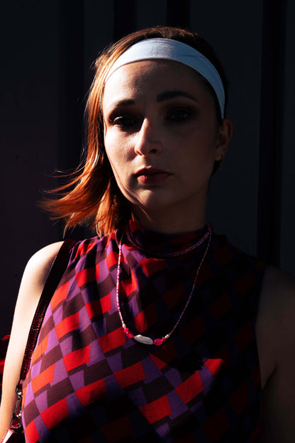 Femme portant un collier Bourjeone rose et fuchsia en perles fines, éclairée par la lumière du soir – collection Sucrée.