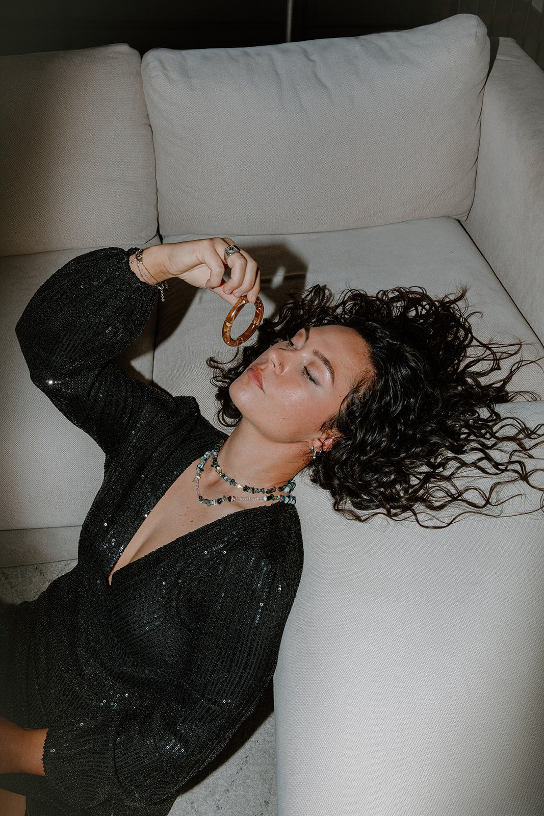 Portrait d'une femme portant le collier Pistachio, montrant l'éclat des perles vertes sur une tenue élégante.