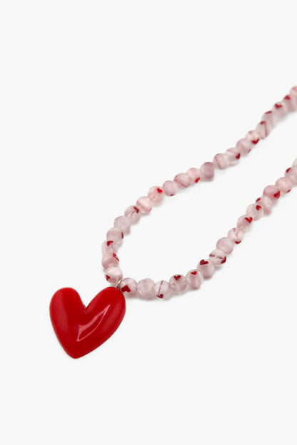 Détail du collier Pomme d’Amour Bourjeone, pendentif rouge vif et perles à cœurs rouges