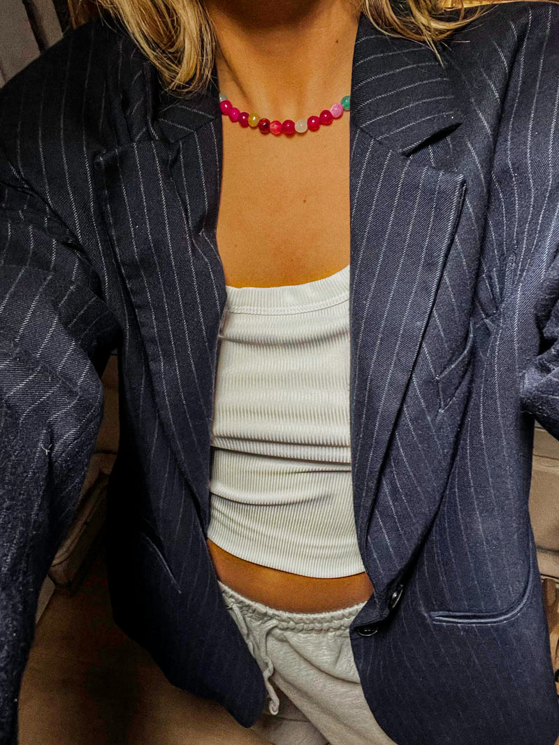 Femme portant le collier Smoothie Bourjeone, bijou fait main composé de perles roses et fuchsia, au style frais et fruité.