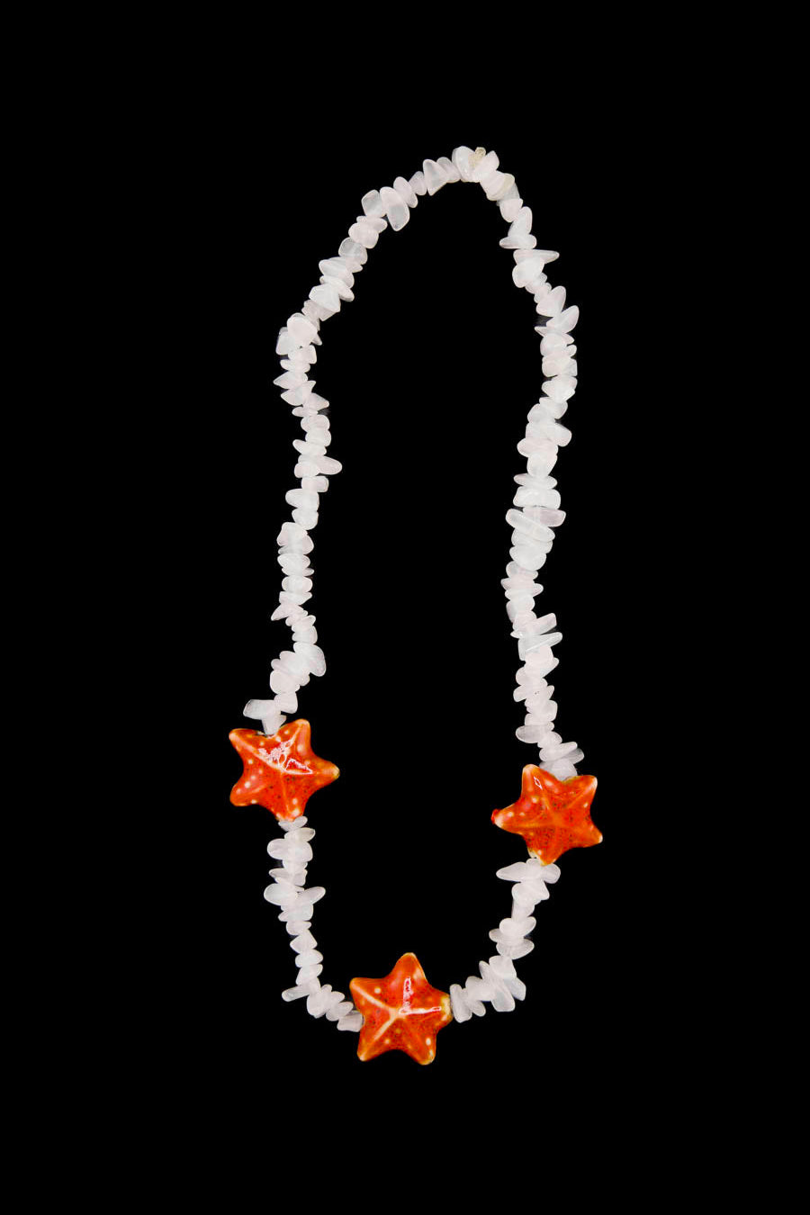 Léger comme une brise d’été — le collier Bourjeone mêle coquillages et éclats orangés pour un look frais et insouciant.