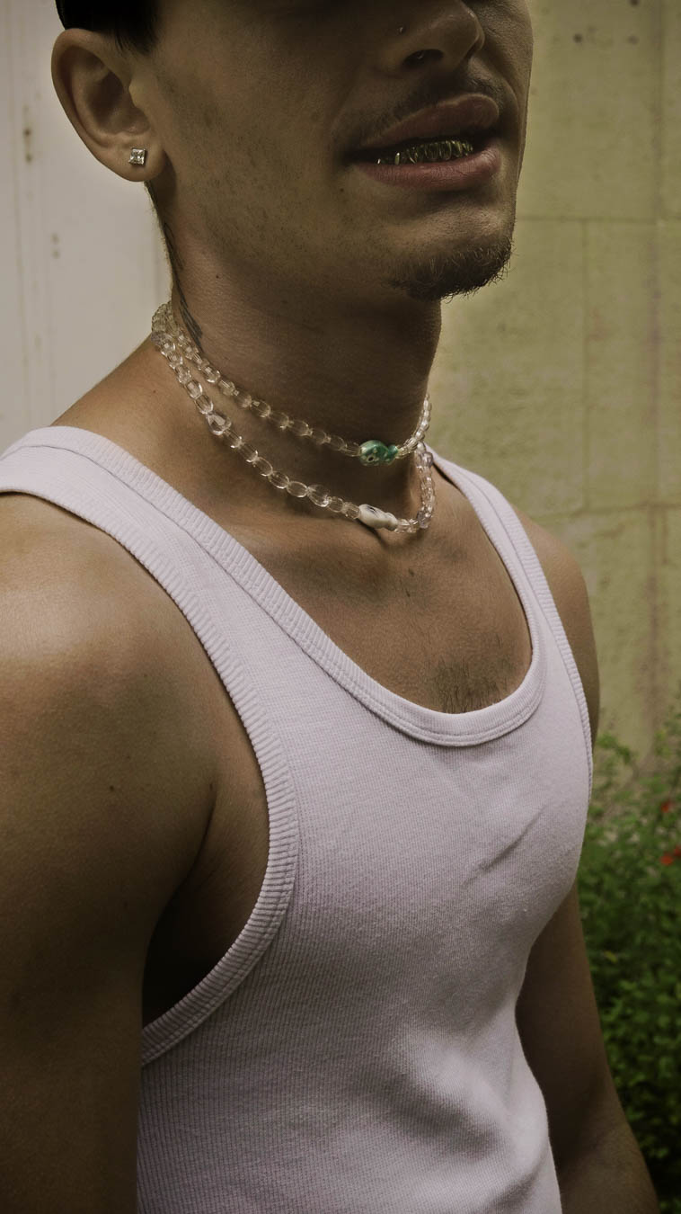 Homme portant le collier Fish & Chips Bourjeone, composé de perles translucides et de détails bleus et nacrés.