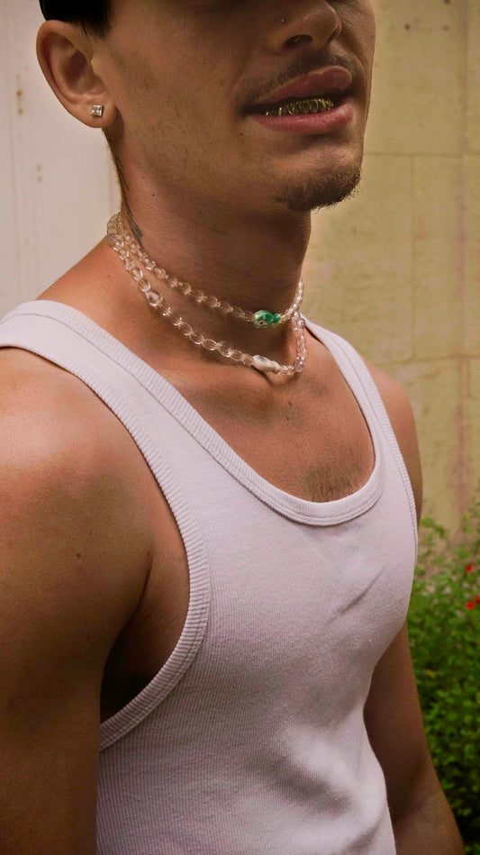 Homme portant le collier Fish & Chips Bourjeone, composé de perles translucides et de détails bleus et nacrés.