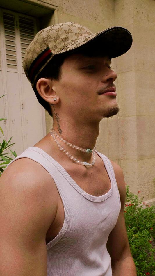 Homme portant le duo Grand Bleu Bourjeone, collier double en perles transparentes et verre turquoise, style frais et lumineux.