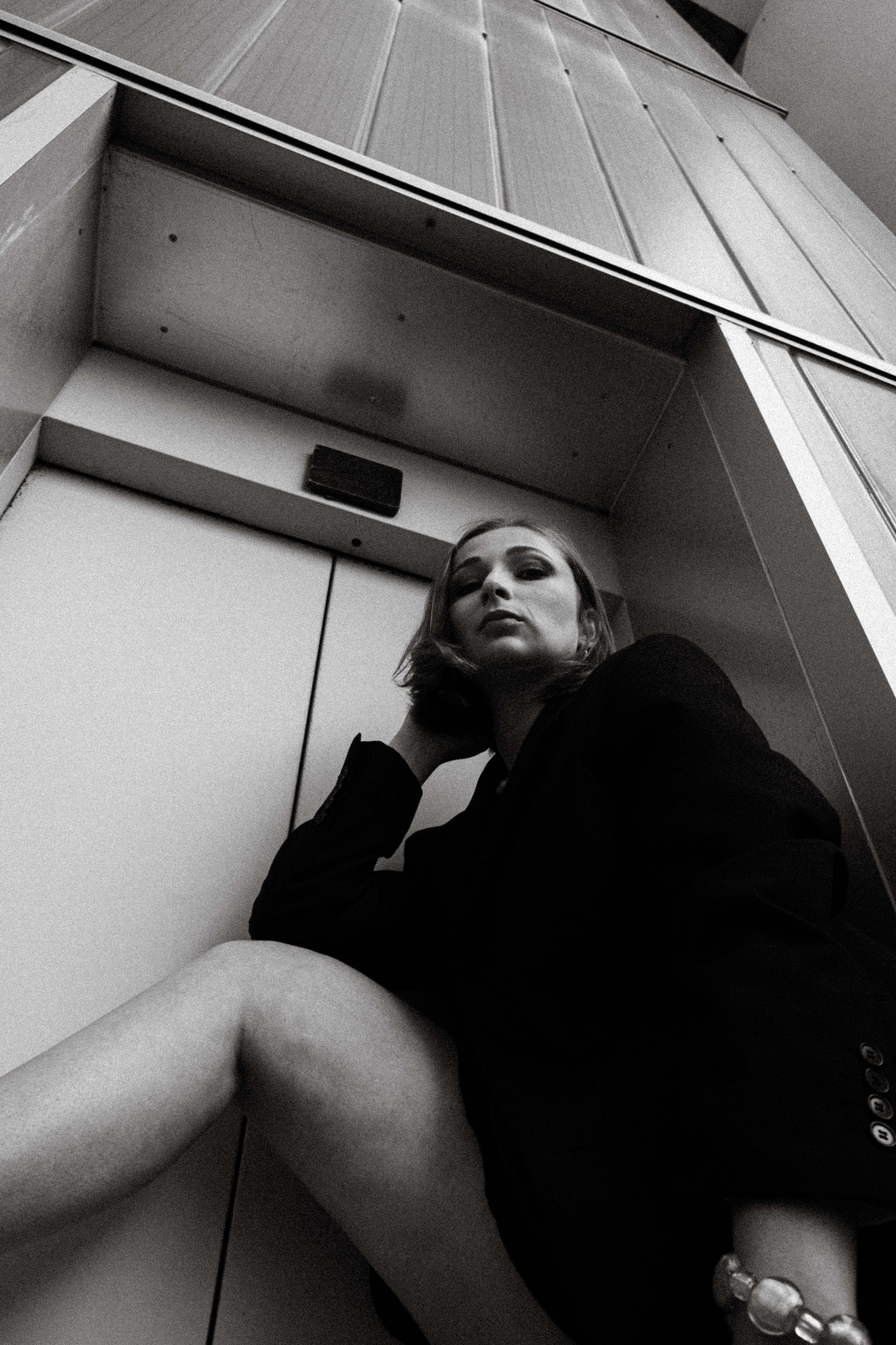 Portrait en noir et blanc d’une femme portant des bijoux Bourjeone, photographiée en contre-plongée – collection Vitaminée.