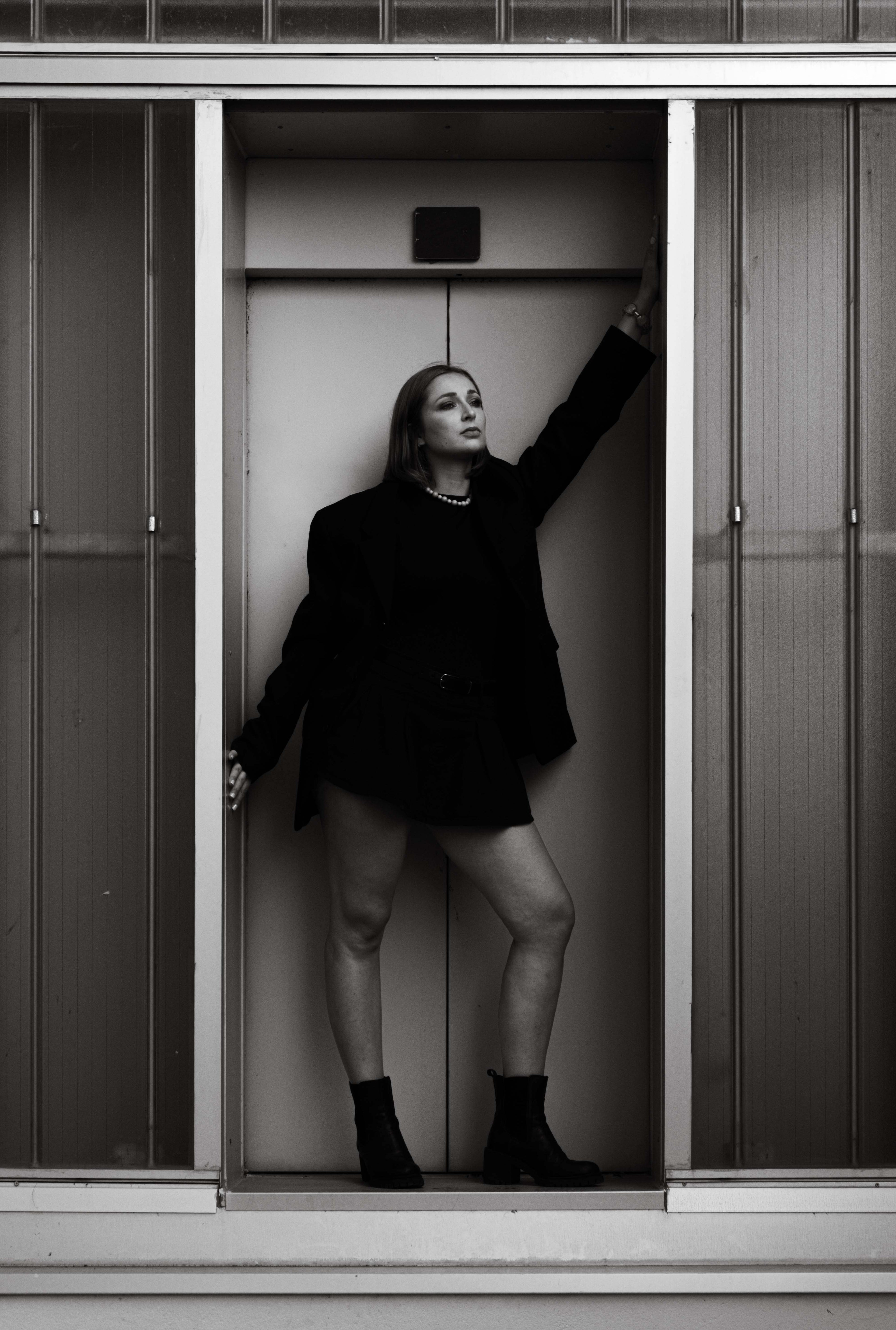 Portrait en noir et blanc d’une femme portant des bijoux Bourjeone et un ensemble noir, incarnant l’audace de la collection Vitaminée.